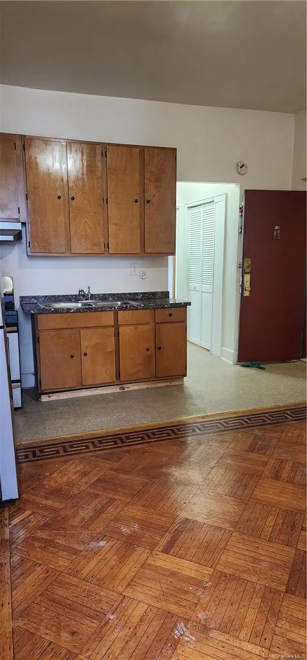 Kitchen with parquet flooring, ventilation hood, refrigerator, and stove Kitchen with parquet flooring, ventilation hood, refrigerator, and stove