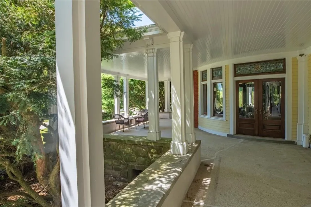 Unfurnished sunroom with french doors and decorative columns Unfurnished sunroom with french doors and decorative columns