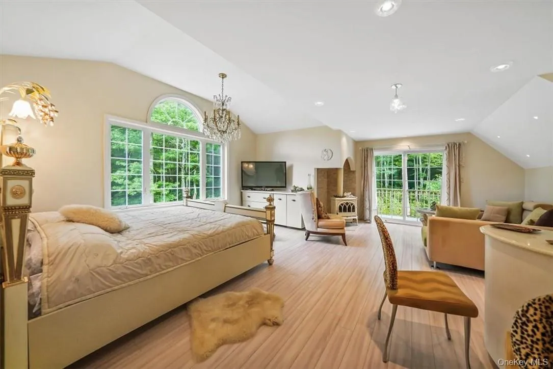 Bedroom with lofted ceiling, hardwood / wood-style floors, and a chandelier Bedroom with lofted ceiling, hardwood / wood-style floors, and a chandelier