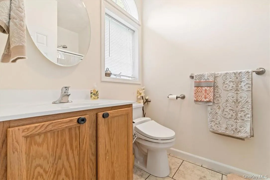 Bathroom featuring vanity, toilet, and tile patterned floors Bathroom featuring vanity, toilet, and tile patterned floors