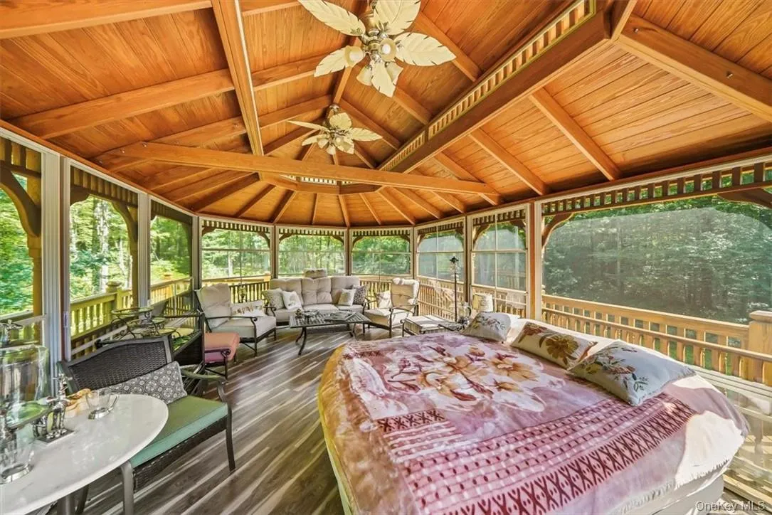Sunroom featuring vaulted ceiling with beams, wood ceiling, and ceiling fan Sunroom featuring vaulted ceiling with beams, wood ceiling, and ceiling fan