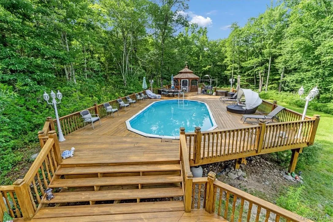 View of pool featuring a wooden deck View of pool featuring a wooden deck