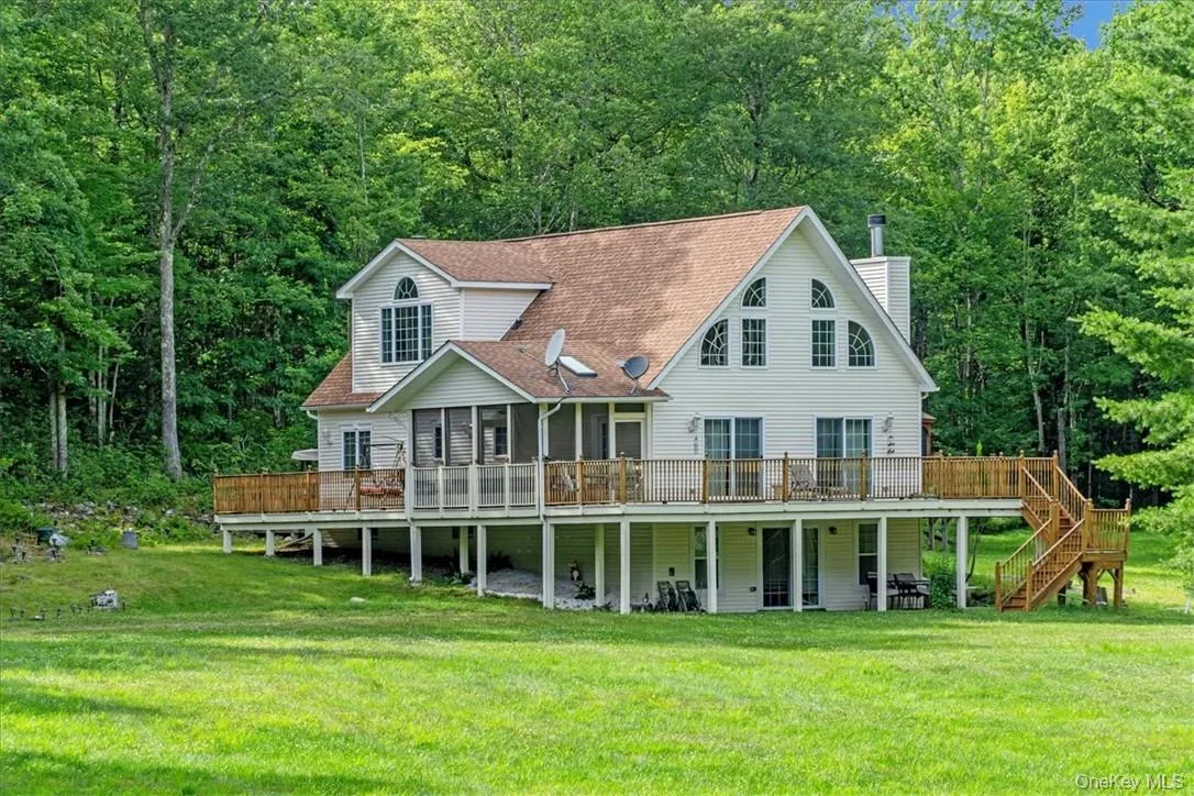 Rear view of property with a yard and a wooden deck Rear view of property with a yard and a wooden deck