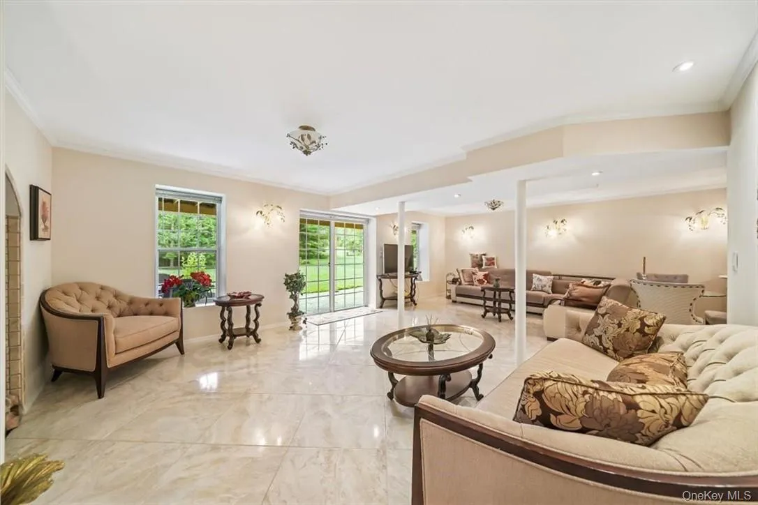 Living room featuring crown molding and light tile patterned floors Living room featuring crown molding and light tile patterned floors