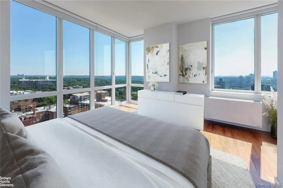 Bedroom with radiator heating unit, expansive windows, and wood-type flooring Bedroom with radiator heating unit, expansive windows, and wood-type flooring