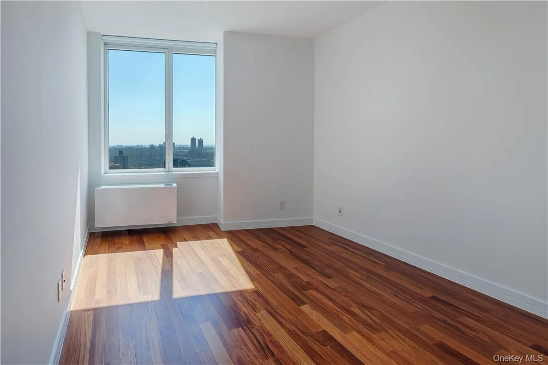 Spare room with radiator heating unit and dark hardwood / wood-style flooring Spare room with radiator heating unit and dark hardwood / wood-style flooring