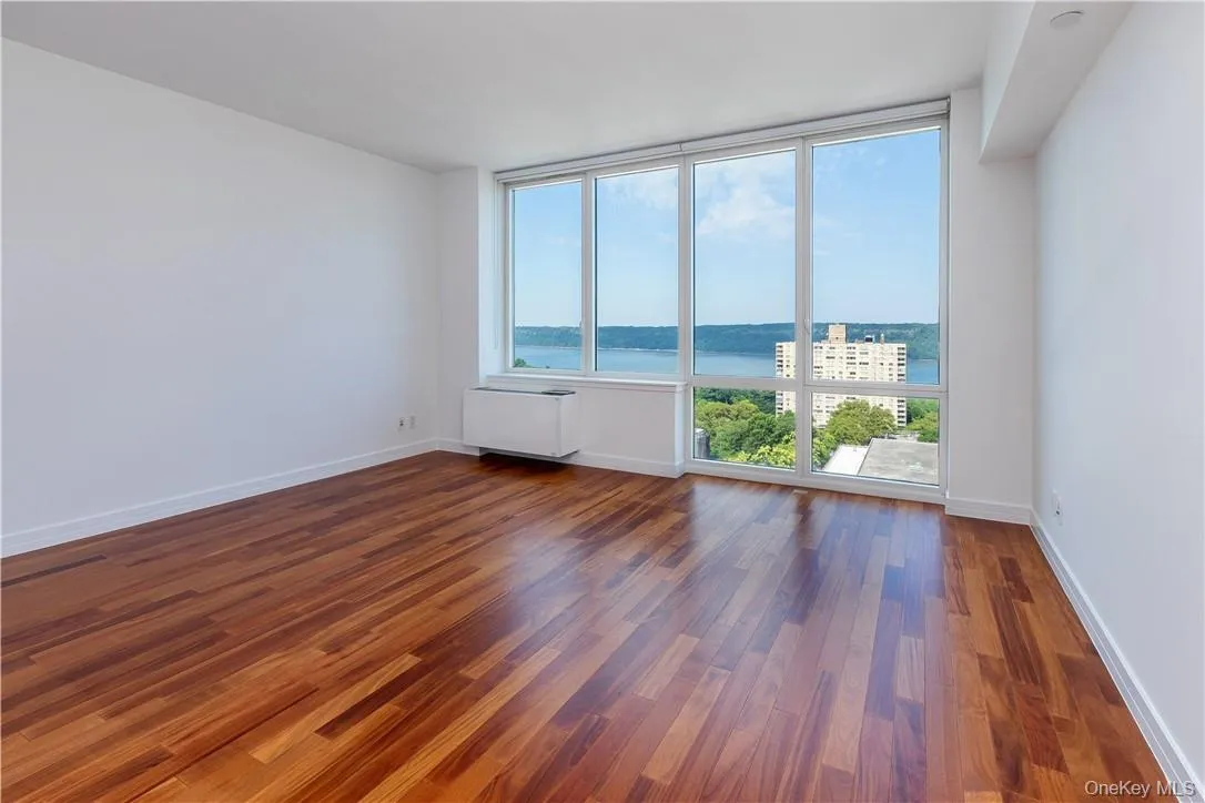 Unfurnished room with dark wood-type flooring and a water view Unfurnished room with dark wood-type flooring and a water view