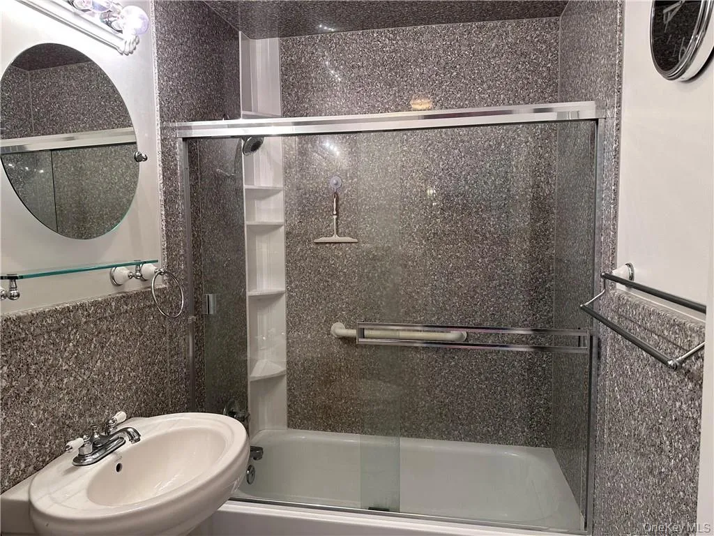 Bathroom featuring combined bath / shower with glass door and sink Bathroom featuring combined bath / shower with glass door and sink