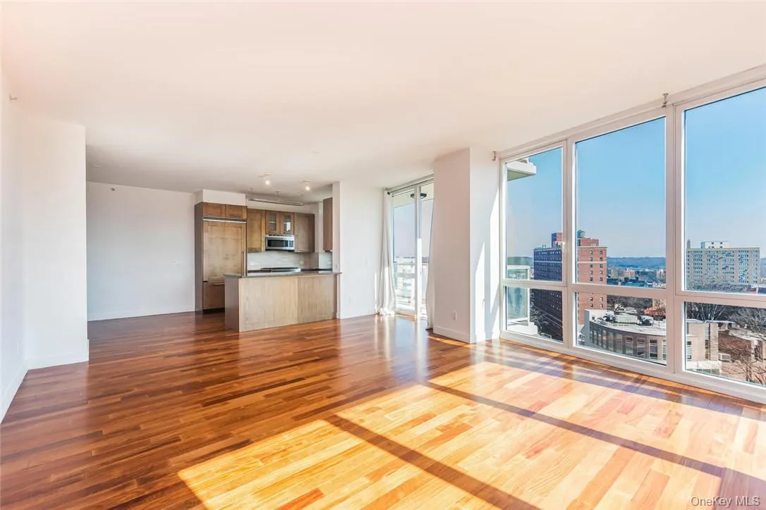 Unfurnished living room with hardwood / wood-style flooring and floor to ceiling windows Unfurnished living room with hardwood / wood-style flooring and floor to ceiling windows
