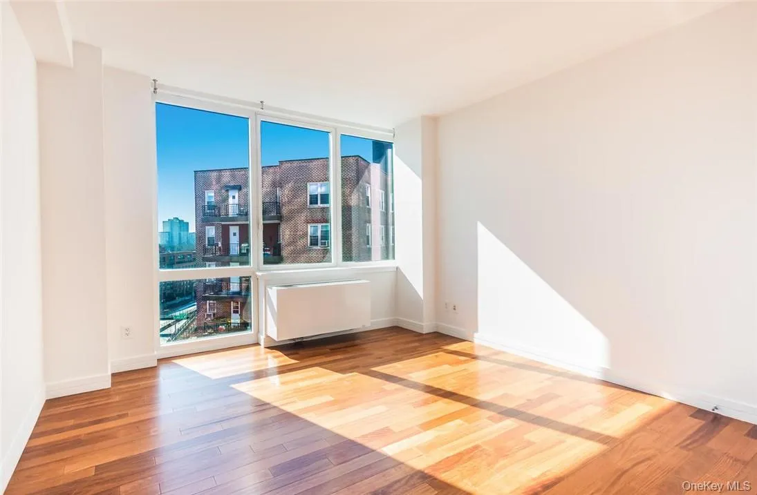 Unfurnished room with radiator and hardwood / wood-style flooring Unfurnished room with radiator and hardwood / wood-style flooring