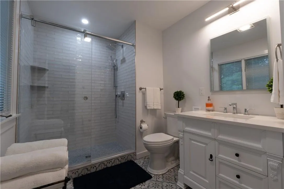 Bathroom with walk in shower, vanity, and toilet Bathroom with walk in shower, vanity, and toilet