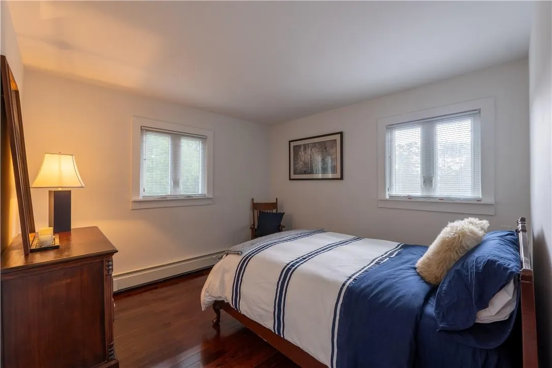 Bedroom featuring dark hardwood / wood-style floors and a baseboard radiator Bedroom featuring dark hardwood / wood-style floors and a baseboard radiator