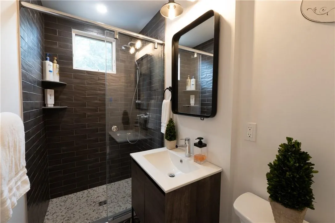 Bathroom featuring walk in shower, vanity, and toilet Bathroom featuring walk in shower, vanity, and toilet