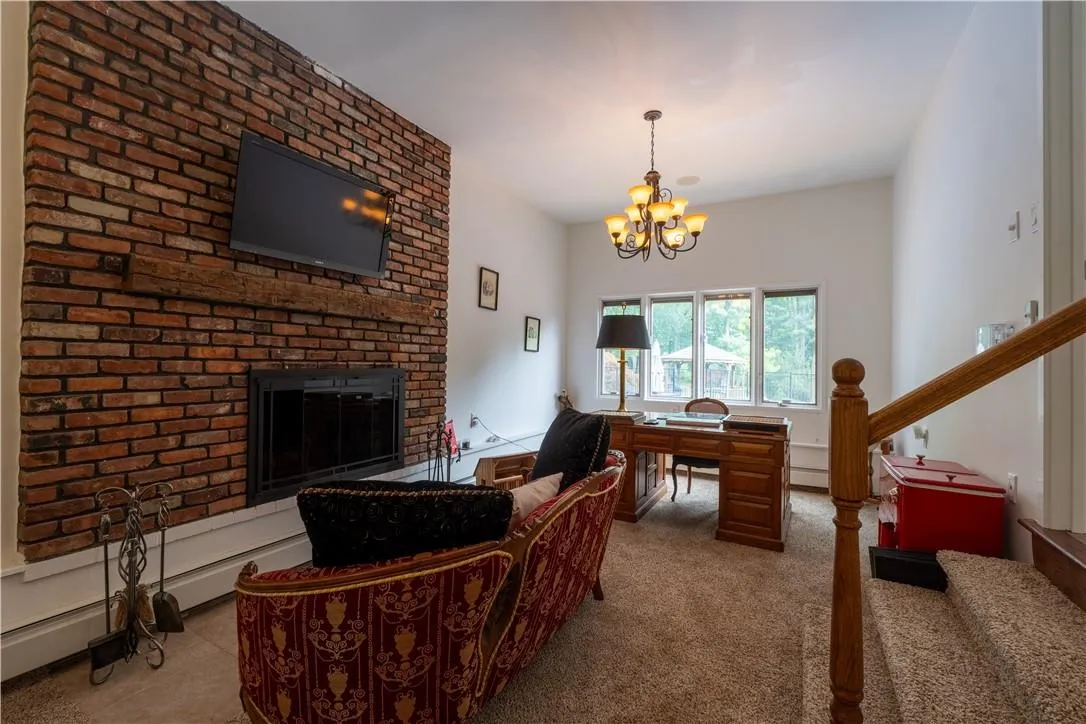 Carpeted office with a brick fireplace and a chandelier Carpeted office with a brick fireplace and a chandelier
