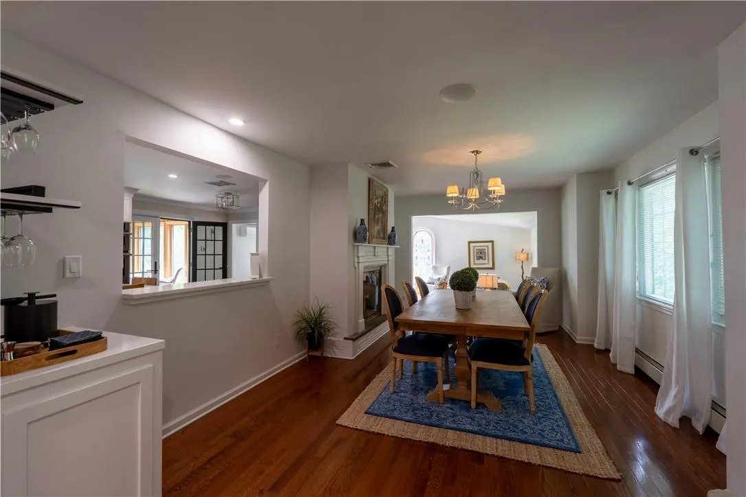 Dining space featuring a baseboard radiator, a notable chandelier, and dark hardwood / wood-style floors Dining space featuring a baseboard radiator, a notable chandelier, and dark hardwood / wood-style floors