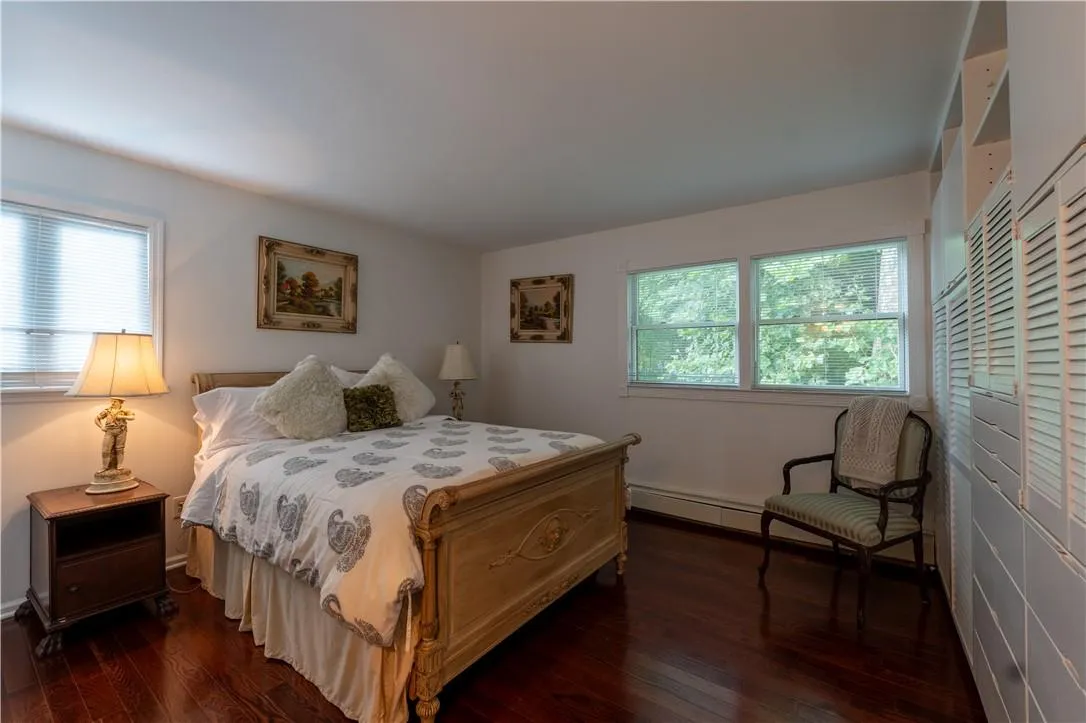 Bedroom with baseboard heating and dark wood-type flooring Bedroom with baseboard heating and dark wood-type flooring