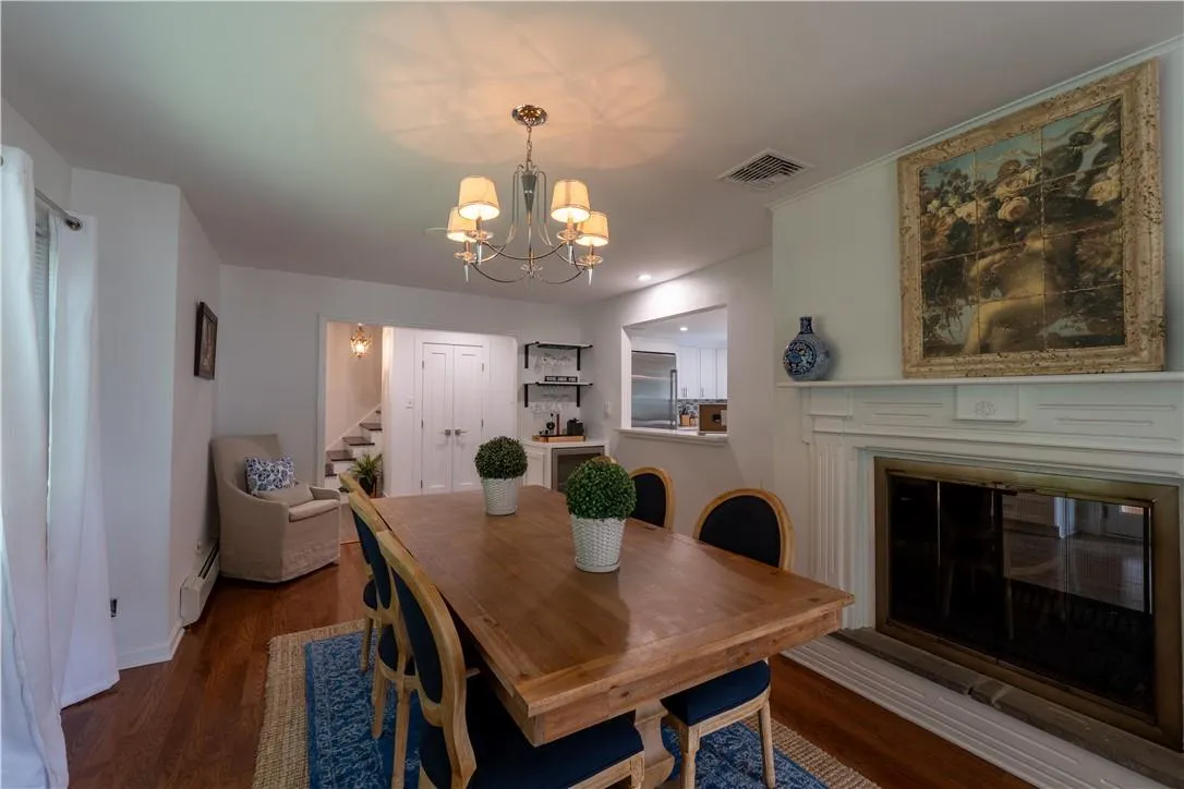 Dining space with an inviting chandelier, a baseboard radiator, and dark wood-type flooring Dining space with an inviting chandelier, a baseboard radiator, and dark wood-type flooring