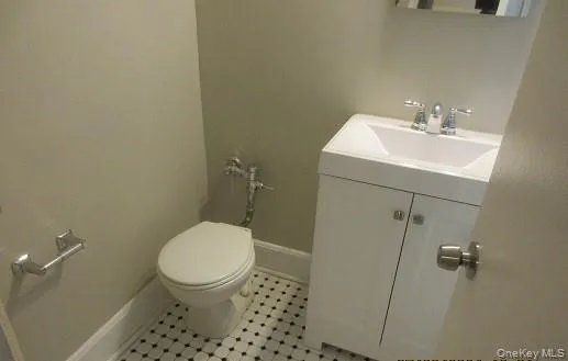 Bathroom featuring vanity, tile patterned flooring, and toilet Bathroom featuring vanity, tile patterned flooring, and toilet