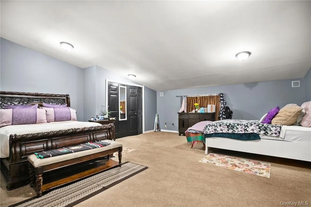 Carpeted bedroom featuring lofted ceiling Carpeted bedroom featuring lofted ceiling