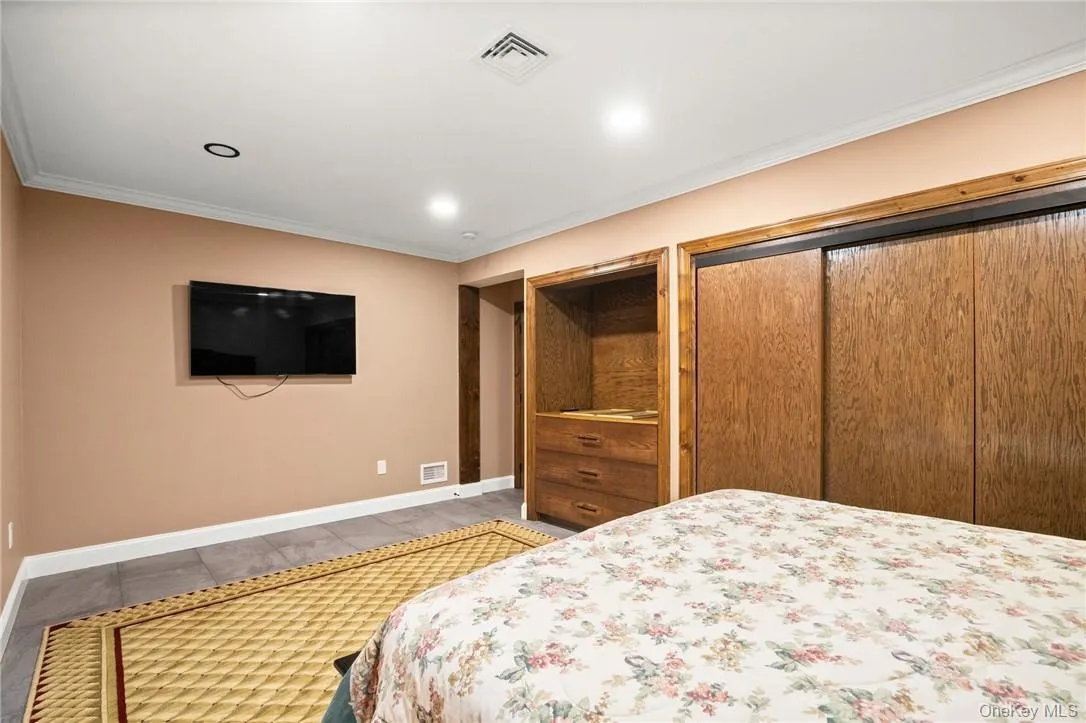 Bedroom featuring ornamental molding and hardwood / wood-style floors Bedroom featuring ornamental molding and hardwood / wood-style floors