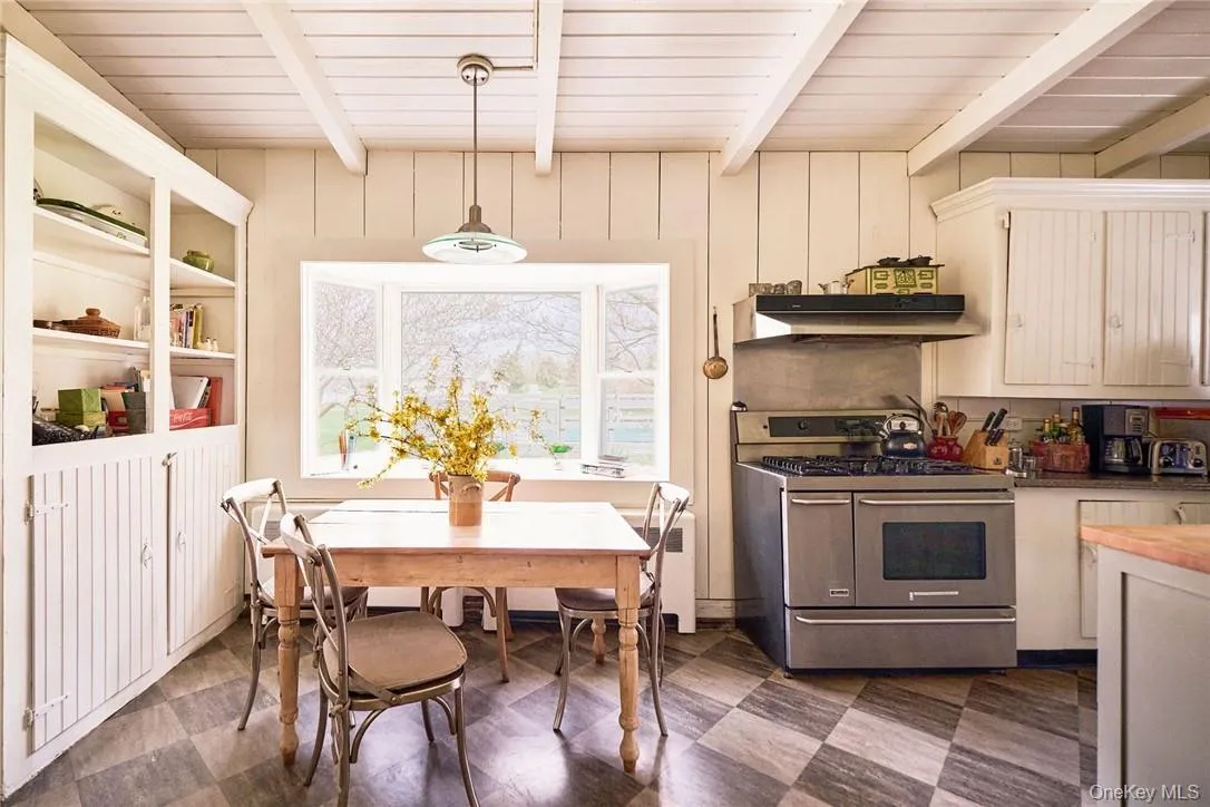 Kitchen featuring decorative light fixtures, beam ceiling, wood ceiling, and stainless steel range oven Kitchen featuring decorative light fixtures, beam ceiling, wood ceiling, and stainless steel range oven