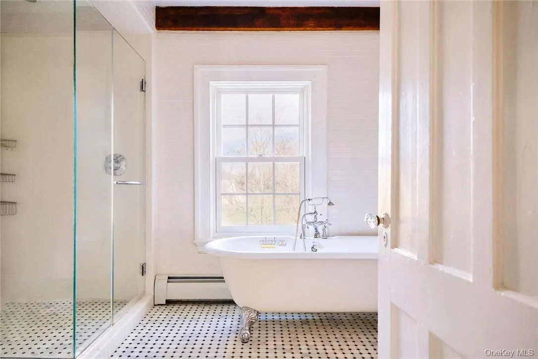 Bathroom featuring baseboard heating and plus walk in shower Bathroom featuring baseboard heating and plus walk in shower