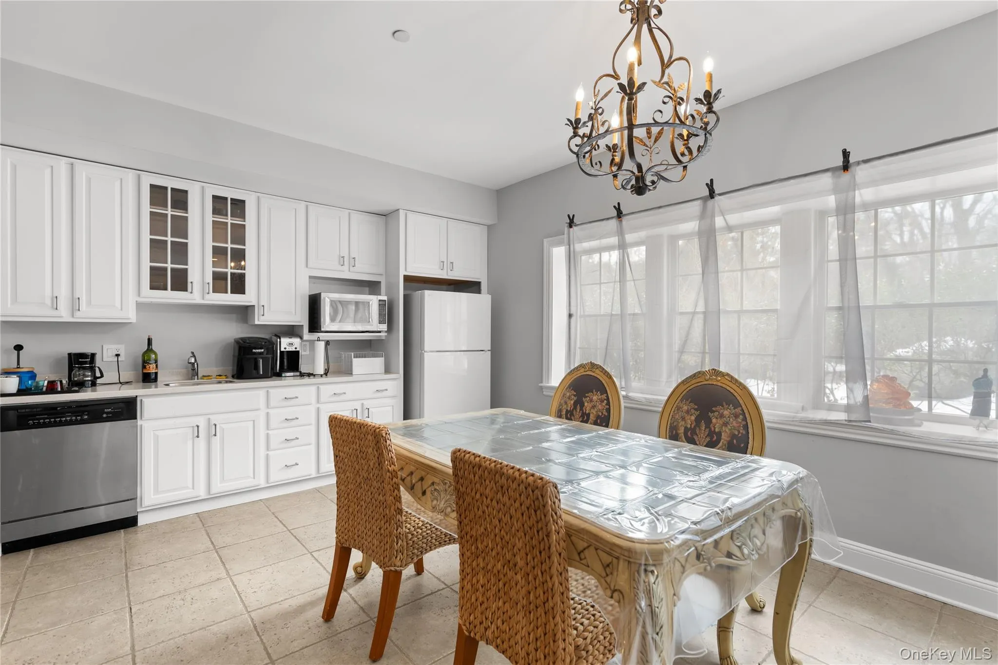 Dining area with suspended lighting and light tile patterned flooring Dining area with suspended lighting and light tile patterned flooring