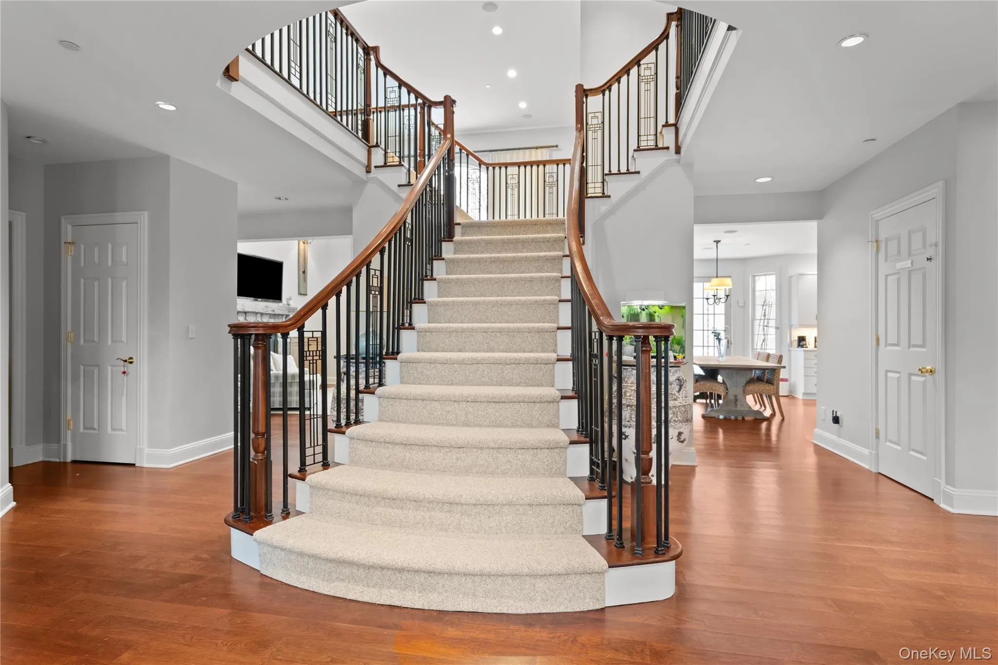 Stairs with wood finished floors, recessed lighting, and a high ceiling Stairs with wood finished floors, recessed lighting, and a high ceiling