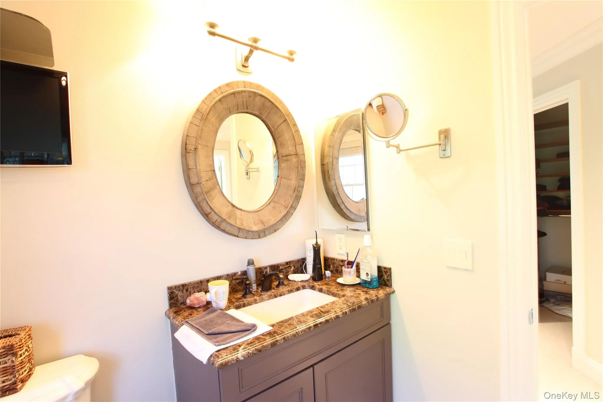 Bathroom vanity featuring a granite countertop, undermount sink, and dark-finish faucet Bathroom vanity featuring a granite countertop, undermount sink, and dark-finish faucet