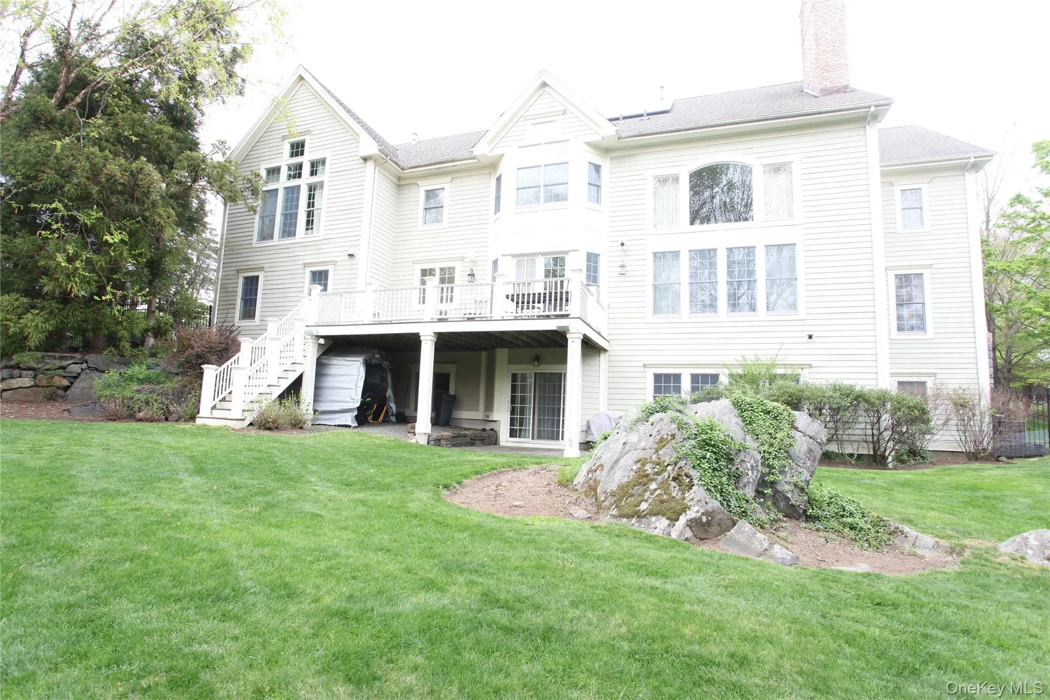 Rear exterior featuring a spacious lawn, multi-level deck, and walk-out lower level Rear exterior featuring a spacious lawn, multi-level deck, and walk-out lower level