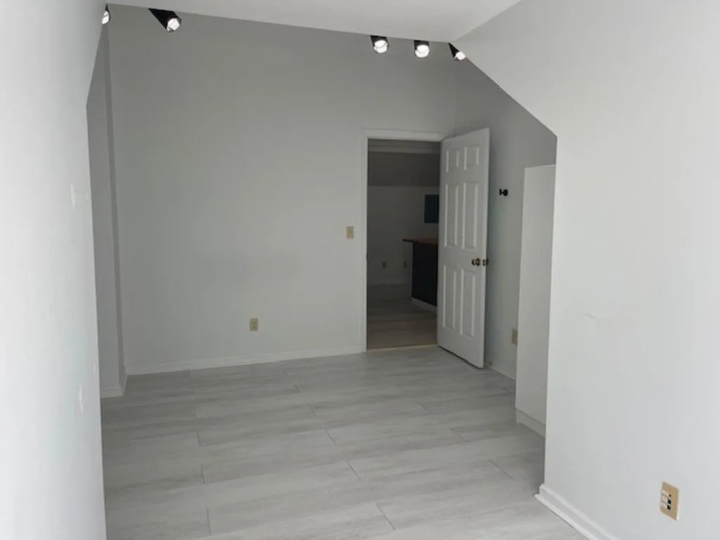 Empty room featuring lofted ceiling Empty room featuring lofted ceiling