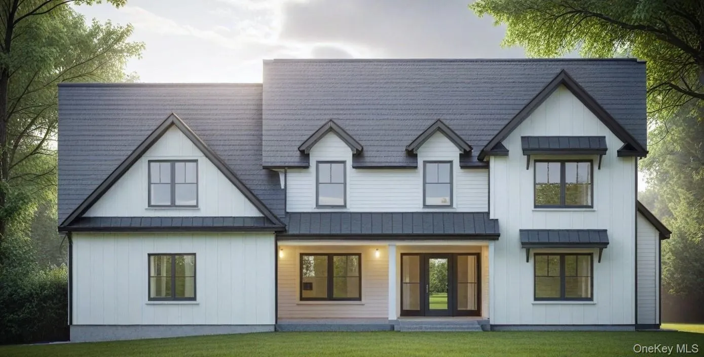 Back of property with a lawn, metal roof, and a standing seam roof Back of property with a lawn, metal roof, and a standing seam roof