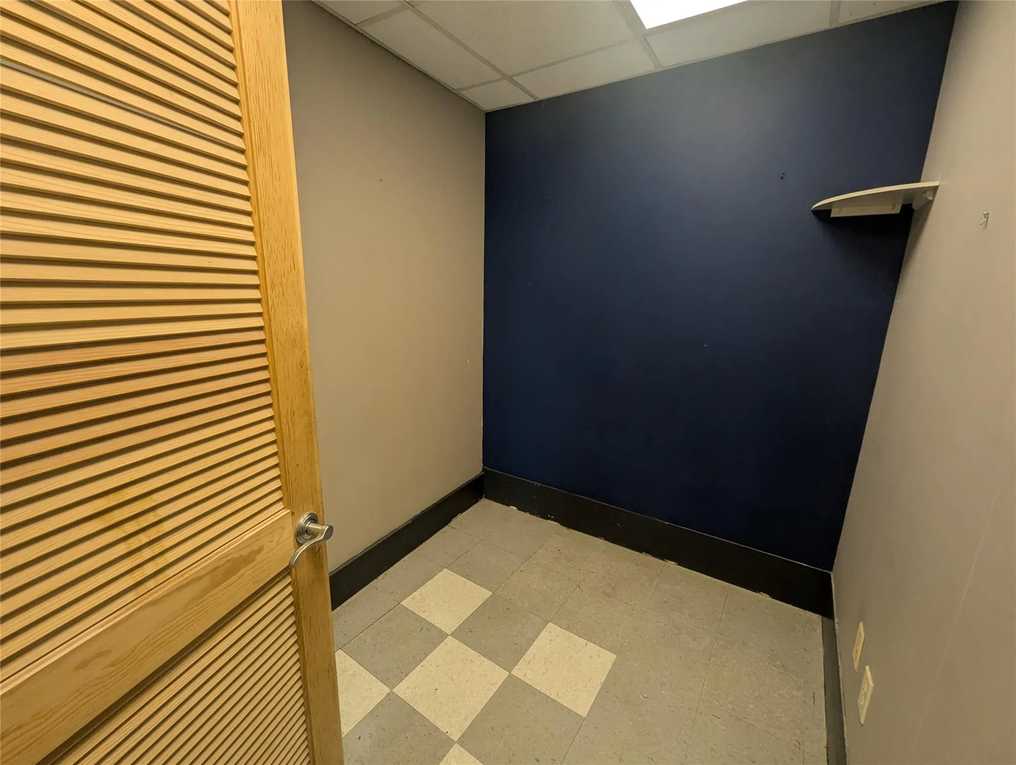 Unfurnished room with light flooring, a drop ceiling, and baseboards Unfurnished room with light flooring, a drop ceiling, and baseboards