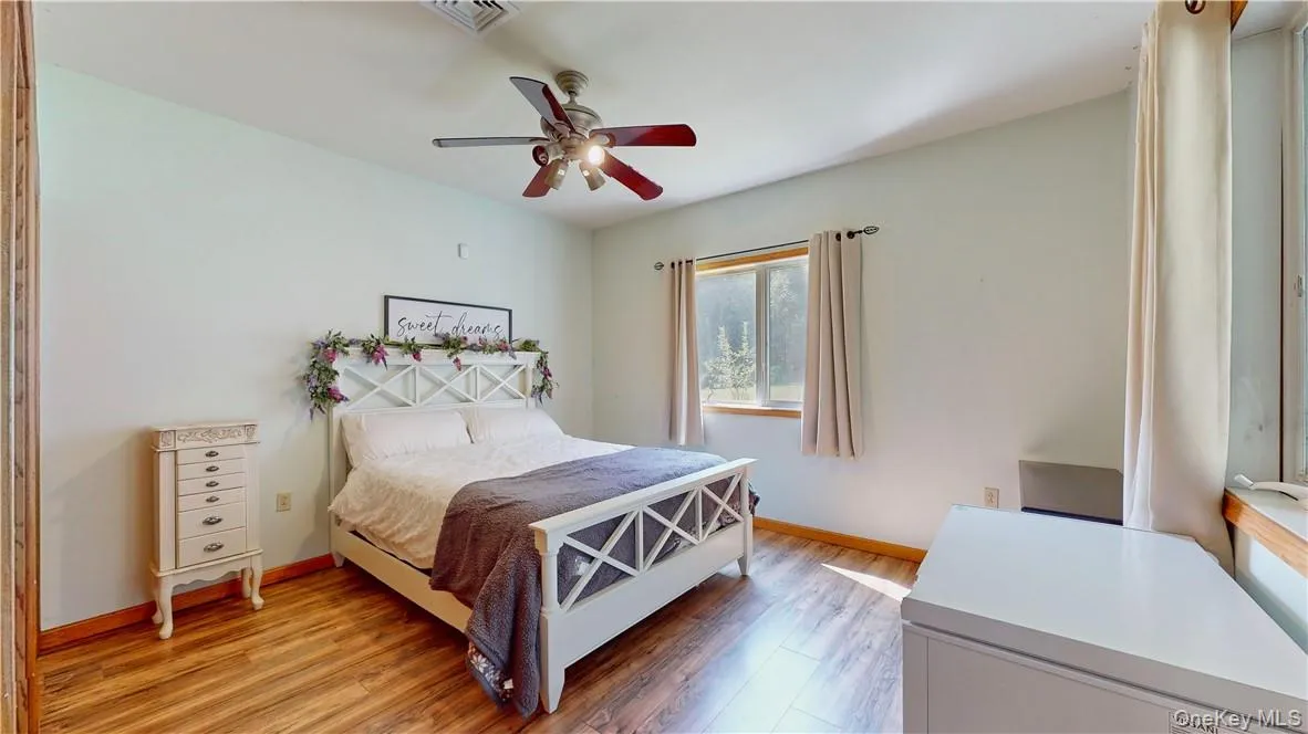 Bedroom featuring ceiling fan and hardwood / wood-style flooring Bedroom featuring ceiling fan and hardwood / wood-style flooring