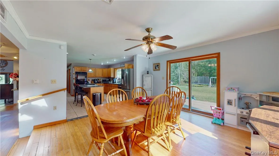Dining space featuring ceiling fan, ornamental molding, and light wood-type flooring Dining space featuring ceiling fan, ornamental molding, and light wood-type flooring