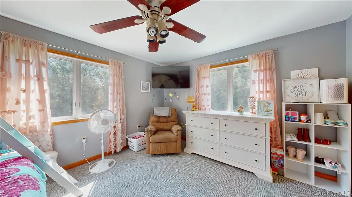 Carpeted bedroom with multiple windows and ceiling fan Carpeted bedroom with multiple windows and ceiling fan