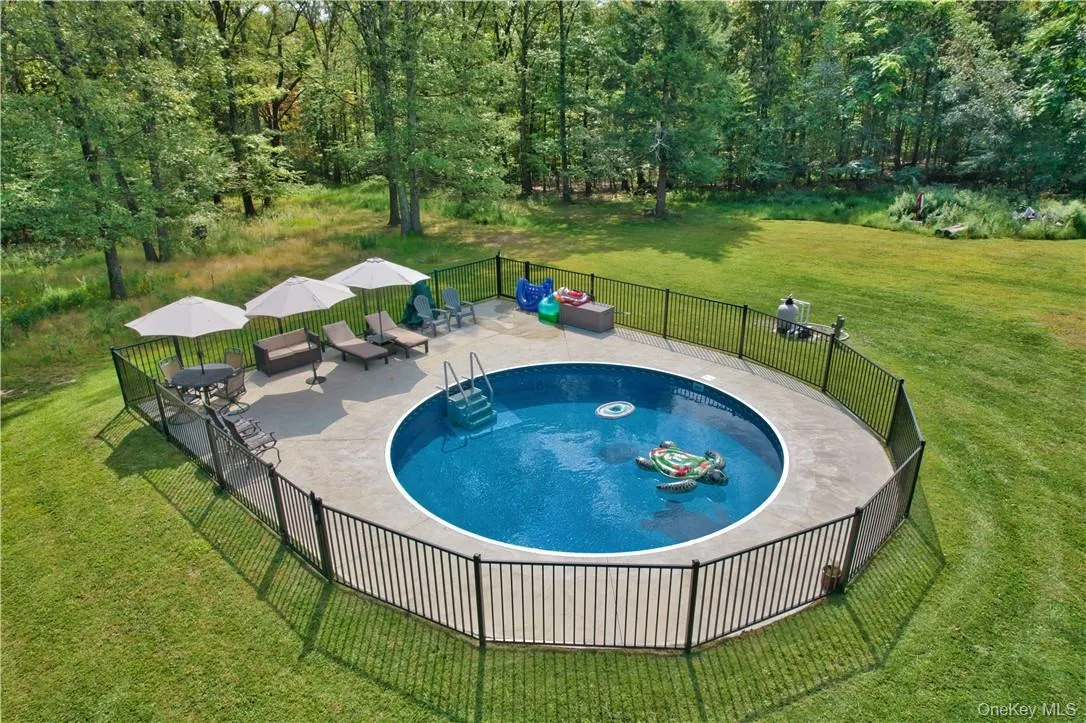 View of swimming pool featuring a patio area and a yard View of swimming pool featuring a patio area and a yard