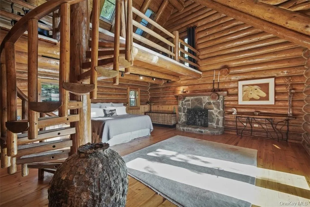 First floor extensive primary suite with woodturning fireplace, walk-in closets and loft accessed by a charming spiral staircase First floor extensive primary suite with woodturning fireplace, walk-in closets and loft accessed by a charming spiral staircase