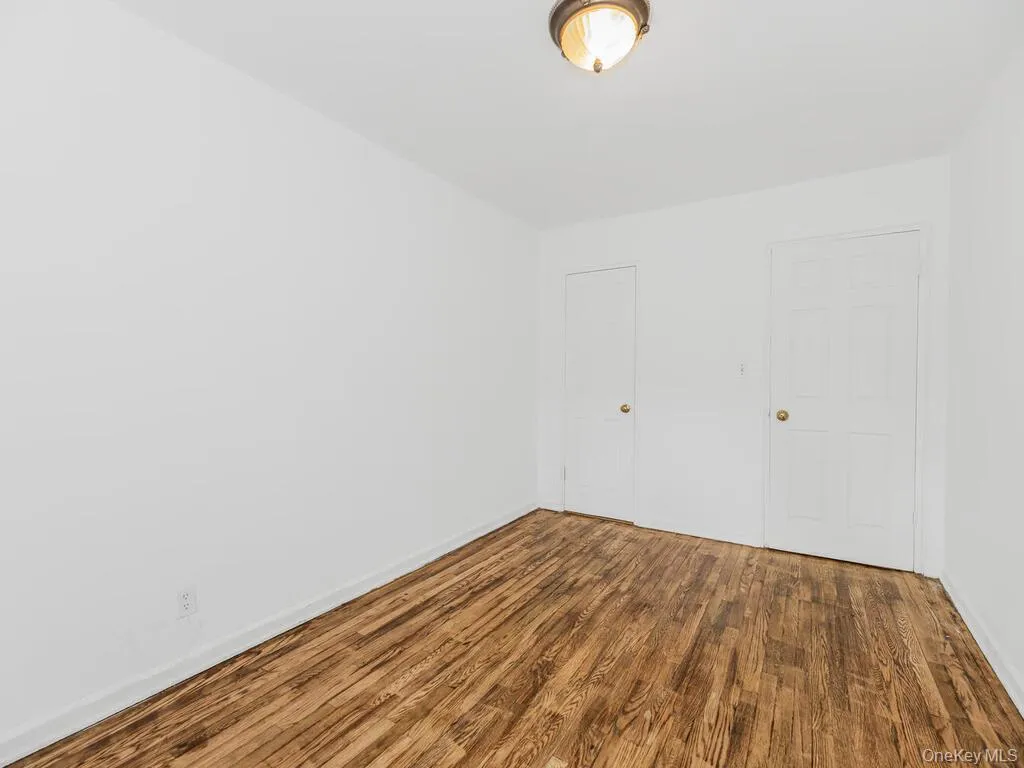 Unfurnished room featuring hardwood / wood-style floors Unfurnished room featuring hardwood / wood-style floors