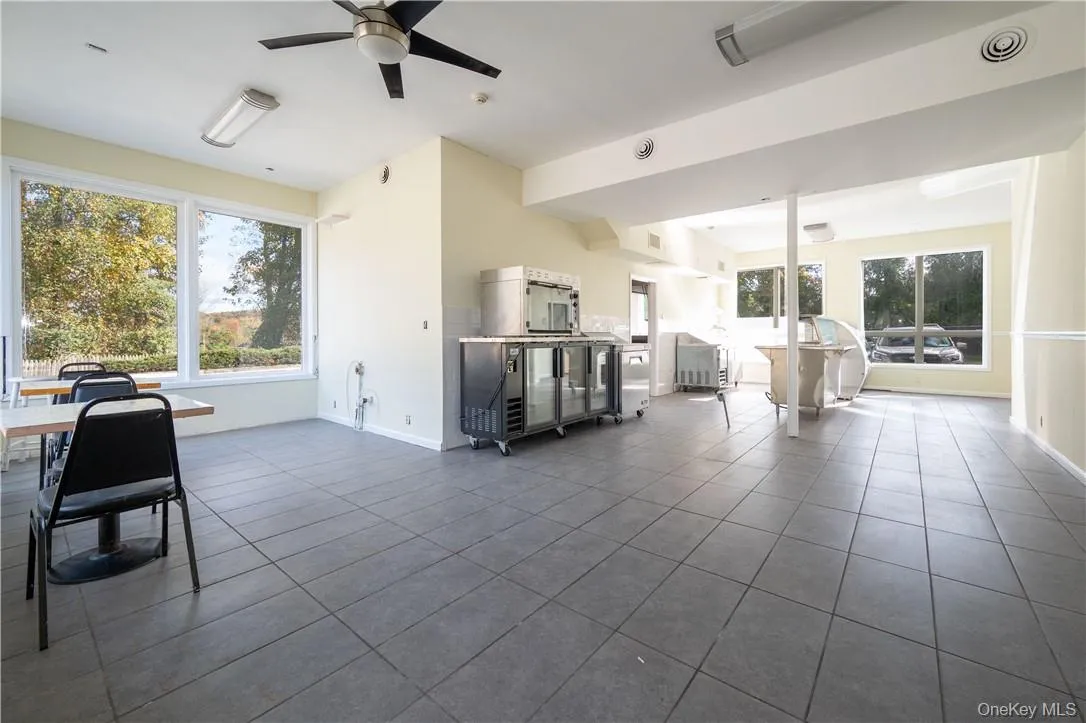 Living room with ceiling fan and tile patterned flooring Living room with ceiling fan and tile patterned flooring