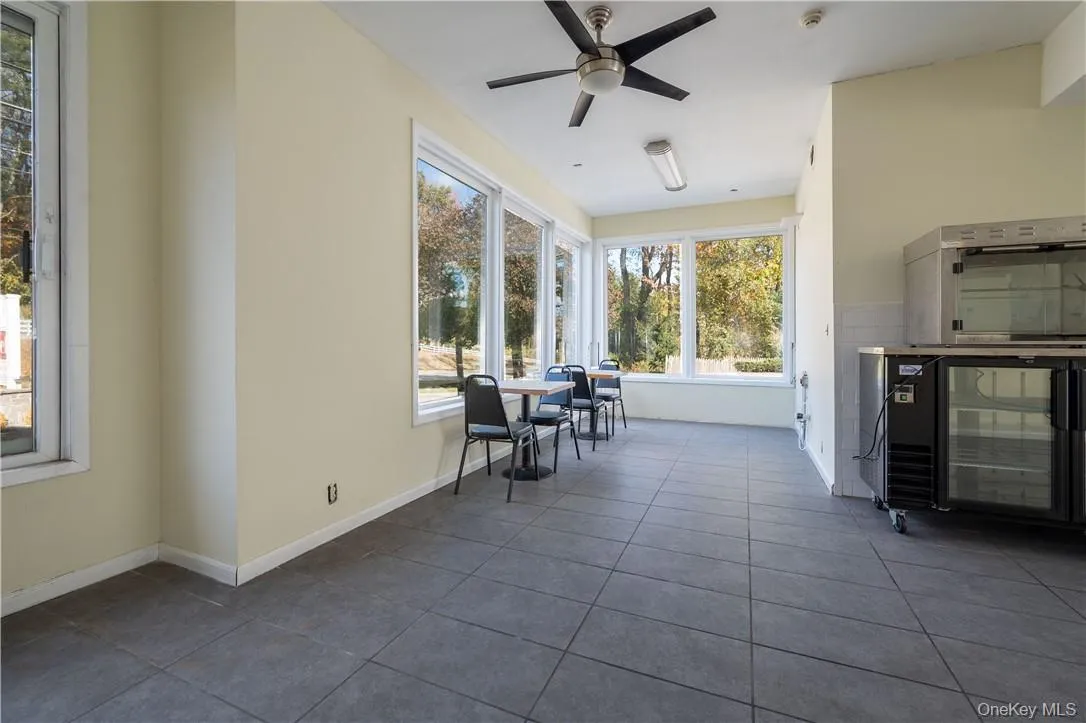 Unfurnished sunroom featuring ceiling fan Unfurnished sunroom featuring ceiling fan