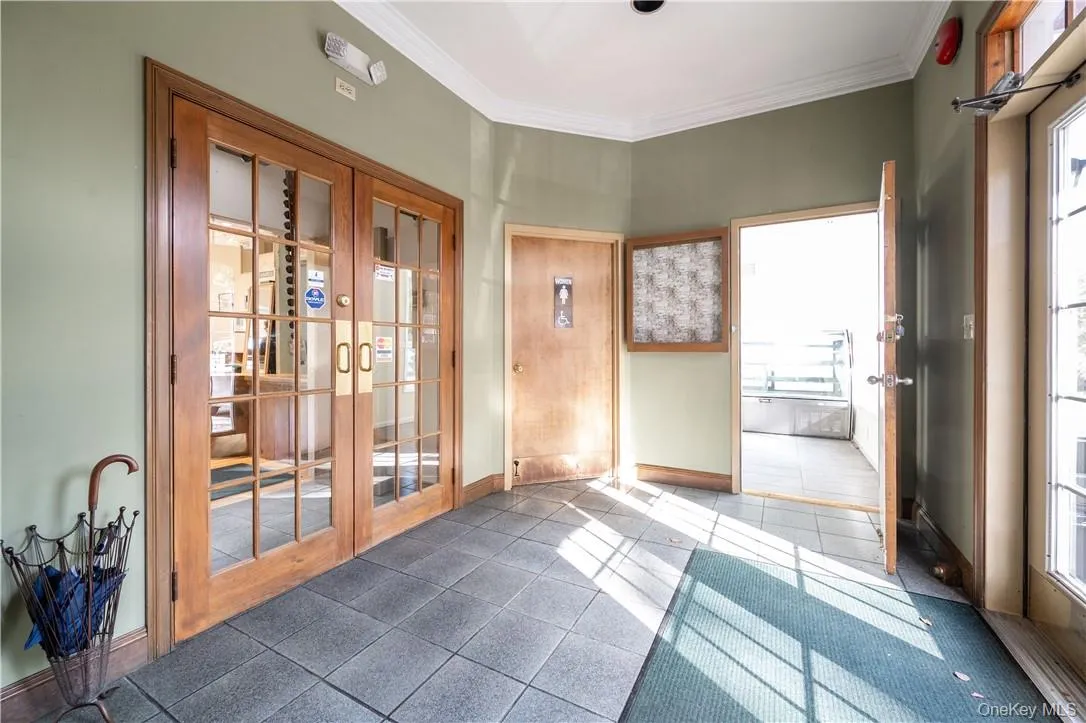 Entryway with french doors, a healthy amount of sunlight, and ornamental molding Entryway with french doors, a healthy amount of sunlight, and ornamental molding