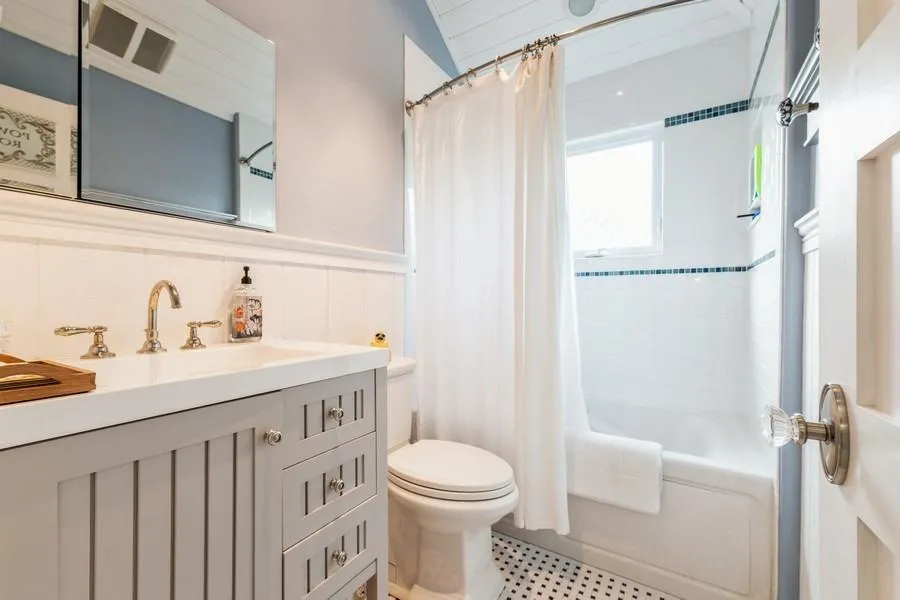 Full bathroom featuring vanity, toilet, tile walls, and shower / tub combo Full bathroom featuring vanity, toilet, tile walls, and shower / tub combo