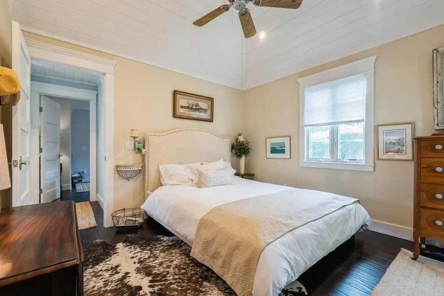 Bedroom with lofted ceiling, dark hardwood / wood-style floors, and ceiling fan Bedroom with lofted ceiling, dark hardwood / wood-style floors, and ceiling fan