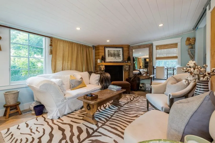 Living room featuring ornamental molding, wood ceiling, a fireplace, and light wood-type flooring Living room featuring ornamental molding, wood ceiling, a fireplace, and light wood-type flooring