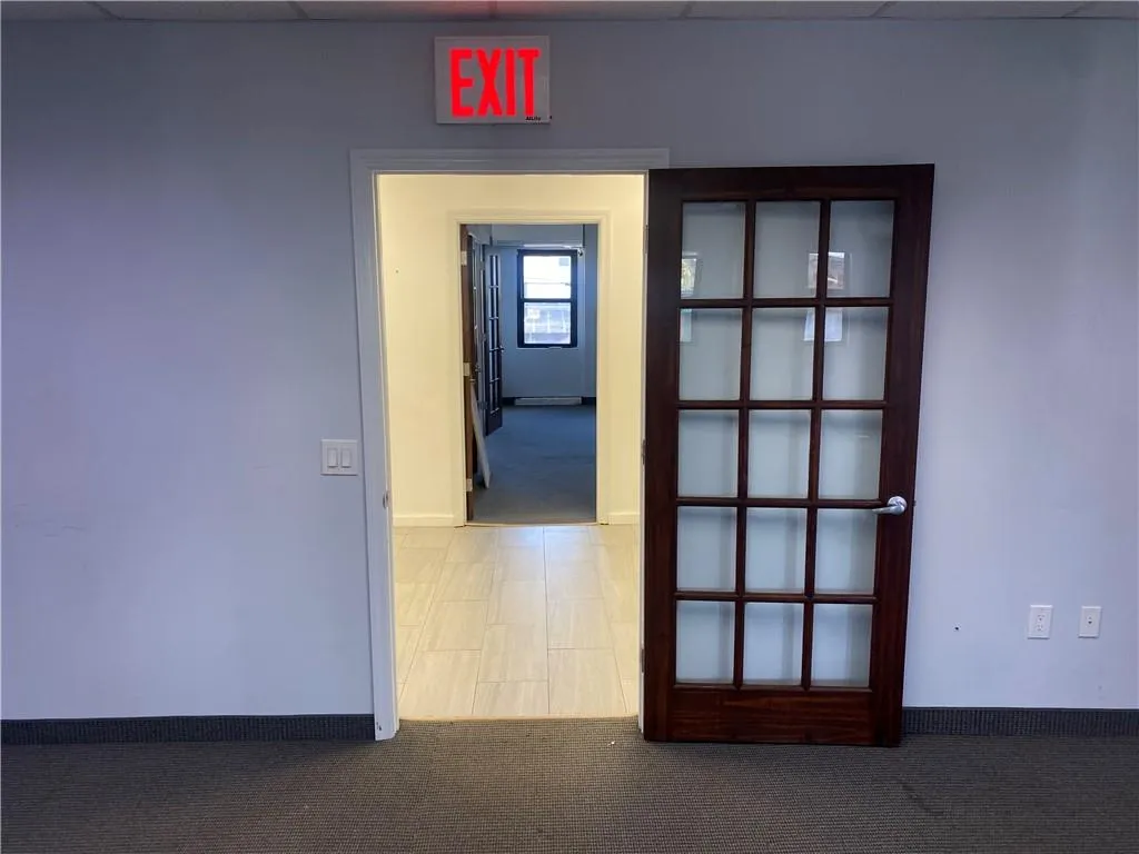 Corridor with a drop ceiling and carpet flooring Corridor with a drop ceiling and carpet flooring