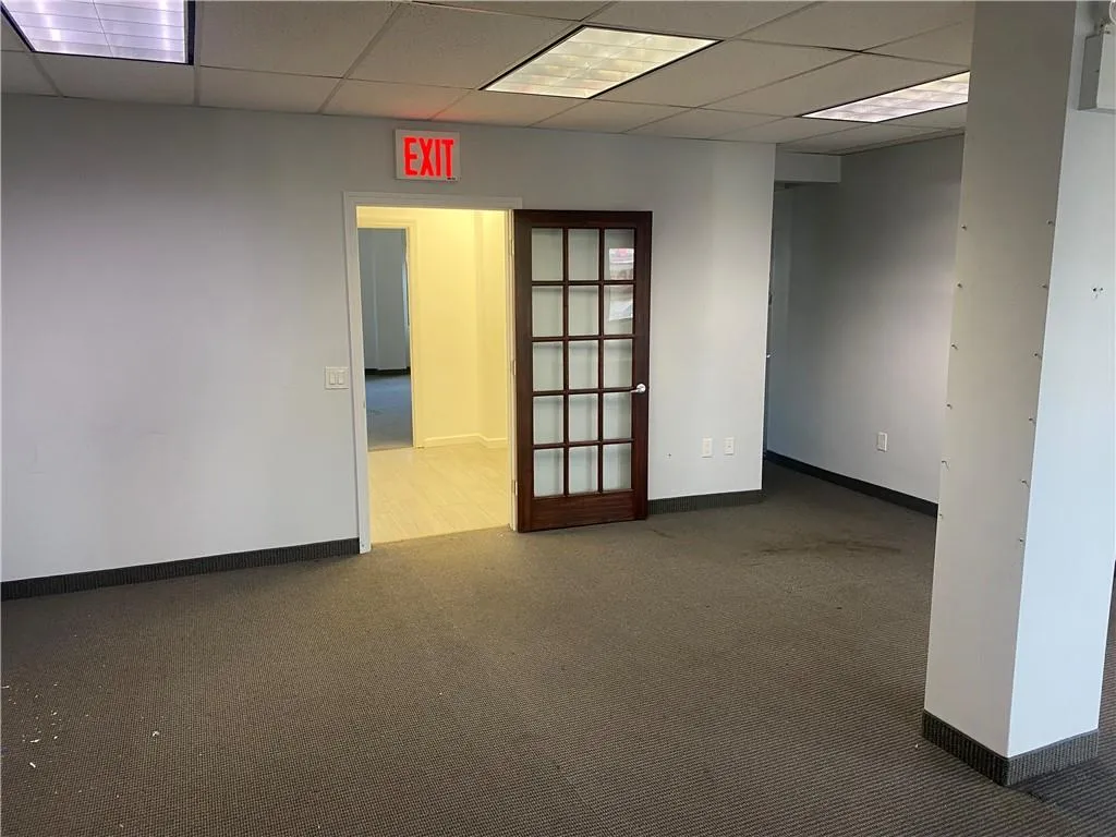 Carpeted empty room featuring a paneled ceiling Carpeted empty room featuring a paneled ceiling