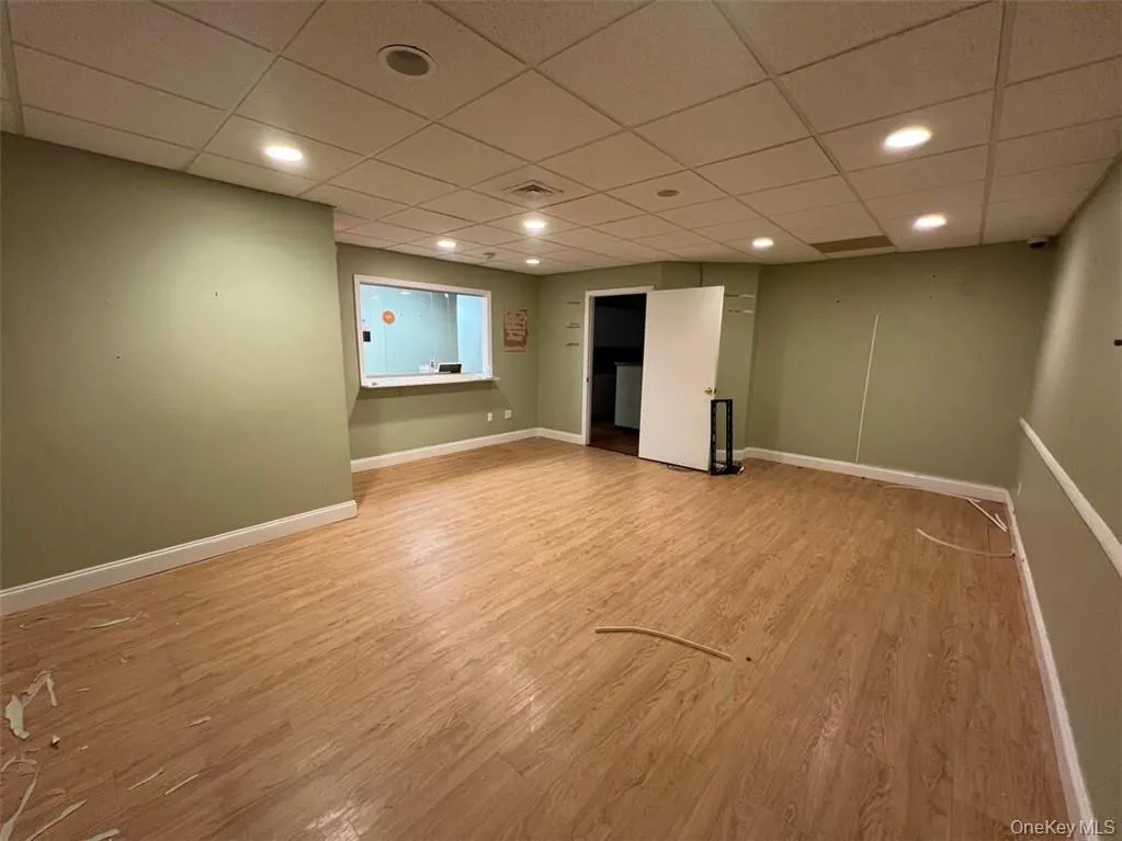 Basement featuring a paneled ceiling and light wood-type flooring Basement featuring a paneled ceiling and light wood-type flooring