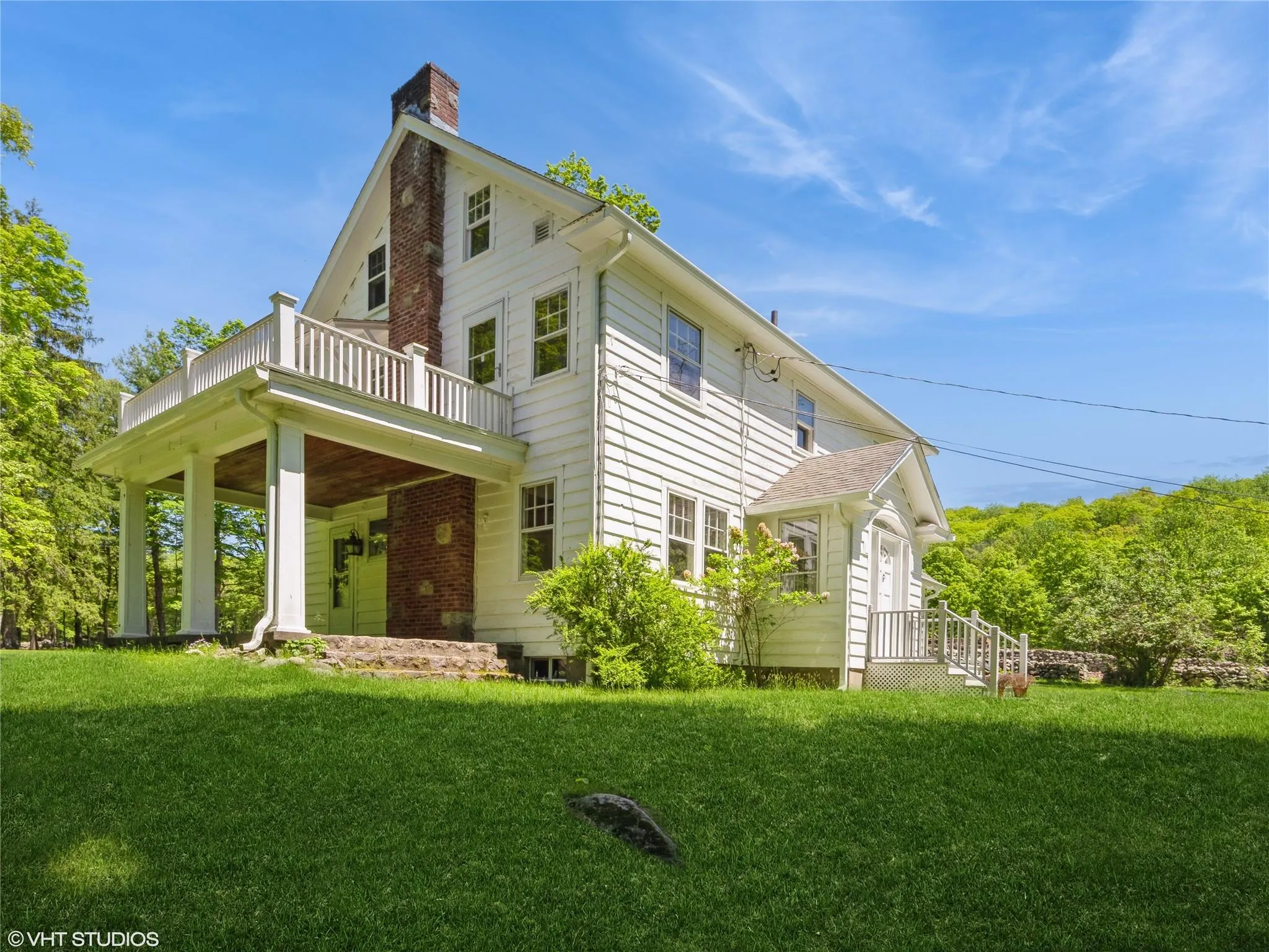 View of property exterior featuring a yard, a chimney, and a balcony View of property exterior featuring a yard, a chimney, and a balcony