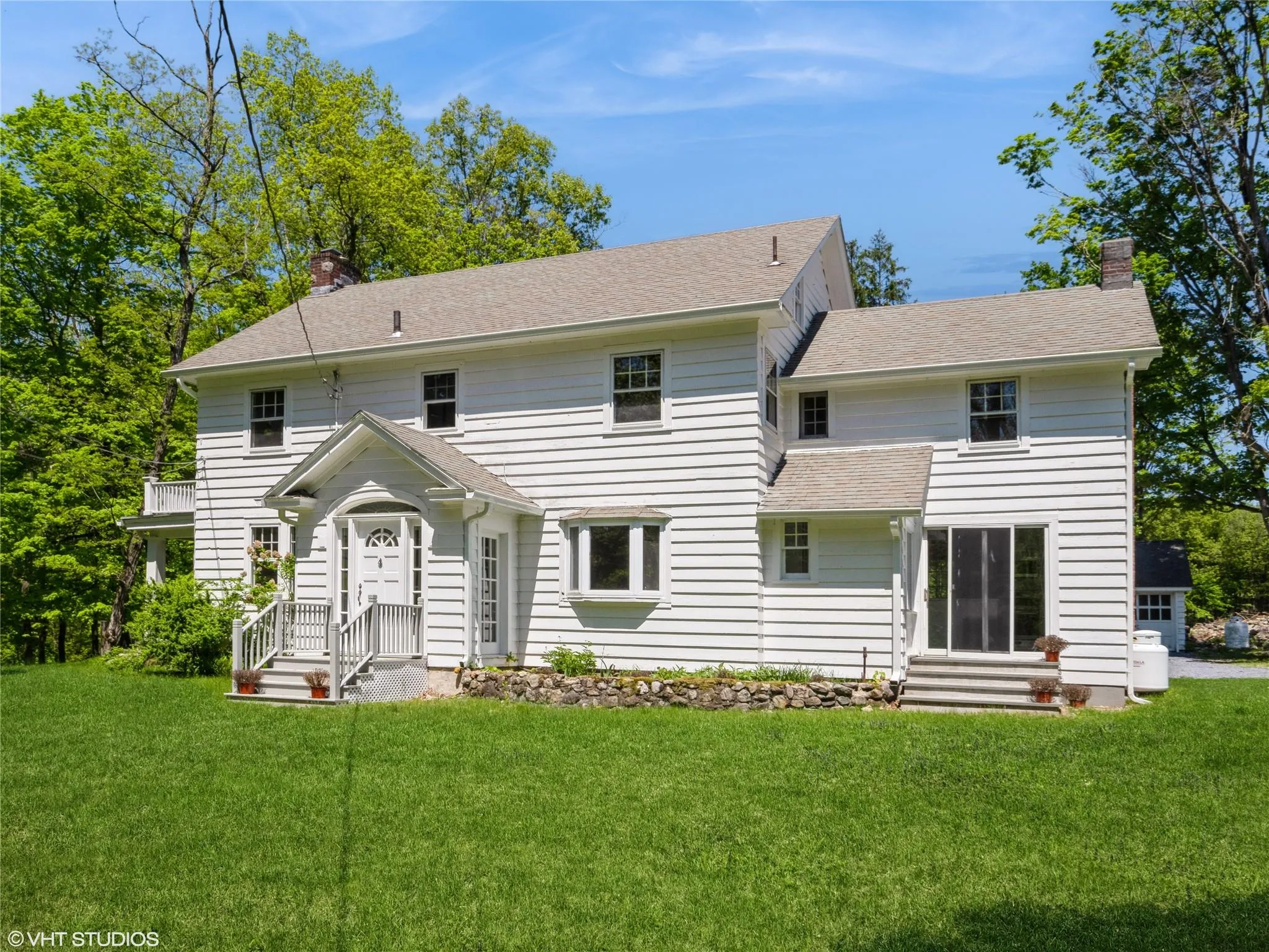 Back of property featuring a chimney, a lawn, and roof with shingles Back of property featuring a chimney, a lawn, and roof with shingles